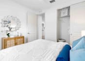Thumbnail 12 of 35 - a white bedroom with a bed and a mirror