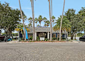 Thumbnail 47 of 61 - A building with a sign in front of it surrounded by palm trees.