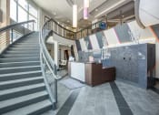 Thumbnail 12 of 33 - the lobby of a building with a staircase and a reception desk