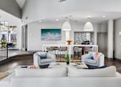Thumbnail 50 of 61 - A modern living room with a white couch and a painting of a wave on the wall.