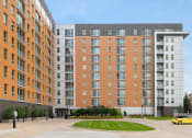 Thumbnail 2 of 45 - a large apartment building on a street with a parking lot at Verge Apartments in St. Louis Park, MN