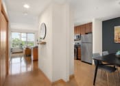 Thumbnail 29 of 45 - a dining room with a table and chairs and a kitchen with stainless steel appliances at Verge Apartments in St. Louis Park, MN