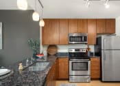 Thumbnail 31 of 45 - a kitchen with granite counter tops and stainless steel appliances at Verge Apartments in St. Louis Park, MN