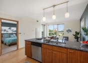 Thumbnail 33 of 45 - an open kitchen and living room with a bedroom in the background at Verge Apartments in St. Louis Park, MN