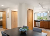 Thumbnail 36 of 45 - a dining room with a table and chairs and a kitchen at Verge Apartments in St. Louis Park, MN