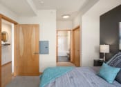 Thumbnail 42 of 45 - a bedroom with a bed and a door to a bathroom at Verge Apartments in St. Louis Park, MN