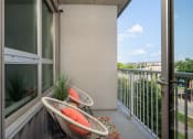 Thumbnail 39 of 45 - a balcony with two chairs and a view of the city at Verge Apartments in St. Louis Park, MN