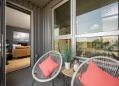 Thumbnail 40 of 45 - a porch with two chairs and a table and windows at Verge Apartments in St. Louis Park, MN