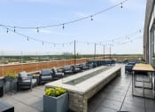 Thumbnail 17 of 45 - the rooftop terrace at the envoy hotel has seating and a view of the city at Verge Apartments in St. Louis Park, MN
