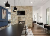 Thumbnail 9 of 45 - a dining room with a long table and chairs and a fireplace at Verge Apartments in St. Louis Park, MN