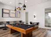 Thumbnail 7 of 45 - a billiards table in a game room with couches and tables at Verge Apartments in St. Louis Park, MN