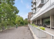 Thumbnail 26 of 45 - the patio of a building with a fence and trees at Verge Apartments in St. Louis Park, MN