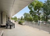 Thumbnail 24 of 45 - the terrace of the building has tables and chairs and a fenceat Verge Apartments in St. Louis Park, MN