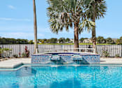 Thumbnail 2 of 61 - A pool surrounded by palm trees and a fence.