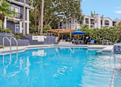 Thumbnail 57 of 61 - A swimming pool with a blue tiled edge and a white sign on the side.