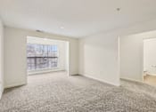 Thumbnail 8 of 58 - A spacious room with a carpeted floor and a window.