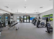 Thumbnail 22 of 35 - a gym with weights and cardio equipment in a building with glass doors