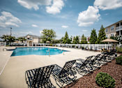 Thumbnail 49 of 64 - A pool surrounded by chairs and trees.