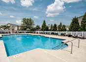 Thumbnail 48 of 64 - A large outdoor swimming pool with a metal ladder on the side.