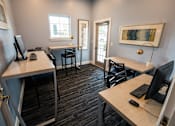Thumbnail 39 of 64 - A room with two desks and chairs, one of which has a computer on it.