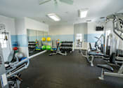 Thumbnail 36 of 64 - A gym with a variety of equipment including a weight bench, a leg press machine, and a treadmill.