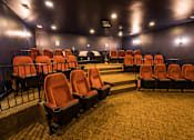 Thumbnail 29 of 64 - A row of orange seats in a dark room.
