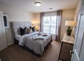 Thumbnail 27 of 64 - A bedroom with a large bed and a window with curtains.