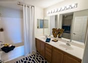 Thumbnail 25 of 64 - A bathroom with a white sink, a mirror, a shower, and a moose head.