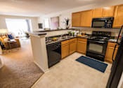 Thumbnail 20 of 64 - A kitchen with black appliances and wooden cabinets.