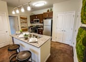 Thumbnail 17 of 64 - A kitchen with a white counter top and brown stools.