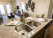 Thumbnail 14 of 64 - A kitchen with a granite countertop and a sink.