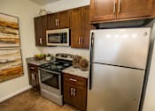 Thumbnail 13 of 64 - A kitchen with a stainless steel refrigerator, microwave, oven, and stove.