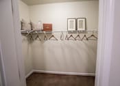 Thumbnail 10 of 64 - A white closet with a brown carpet and a brown hanger.
