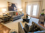 Thumbnail 7 of 64 - A living room with a brown leather couch and a painting of a horse on the wall.