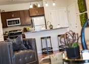 Thumbnail 4 of 64 - A modern kitchen with a black leather chair and a white fridge.