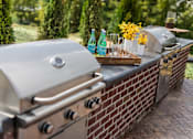 Thumbnail 55 of 64 - A silver grill with a tray of condiments and two bottles of soda on it.
