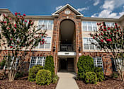 Thumbnail 64 of 64 - A red brick building with a large arched entrance and a walkway leading to it.