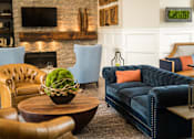 Thumbnail 42 of 64 - A living room with a blue couch and a fireplace.