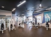 Thumbnail 36 of 58 - A gym with a variety of equipment including treadmills, weights, and exercise machines.