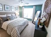 Thumbnail 17 of 58 - A bedroom with a large bed and a ceiling fan.