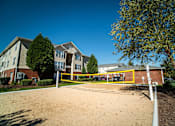 Thumbnail 24 of 58 - A sandy area in front of a building with a yellow fence.