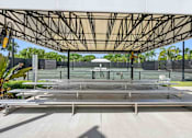 Thumbnail 32 of 35 - a covered pavilion over a tennis court with benches