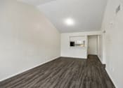 Thumbnail 5 of 21 - A room with wooden flooring and white walls.