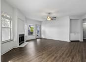 Thumbnail 8 of 61 - A spacious room with a fireplace and wood flooring.