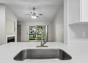 Thumbnail 26 of 61 - A modern kitchen with a stainless steel sink and a ceiling fan.