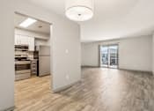 Thumbnail 22 of 35 - A spacious room with wooden flooring and a kitchen area in the background.