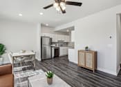Thumbnail 6 of 16 - A modern kitchen with a dining table and a ceiling fan.