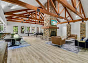 Thumbnail 62 of 71 - A living room with a stone fireplace and wooden beams.
