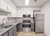Thumbnail 14 of 35 - A kitchen with a stainless steel refrigerator, oven, and sink.