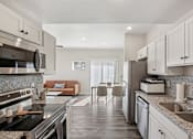 Thumbnail 2 of 16 - A modern kitchen with a black stove top oven and a marble counter top.